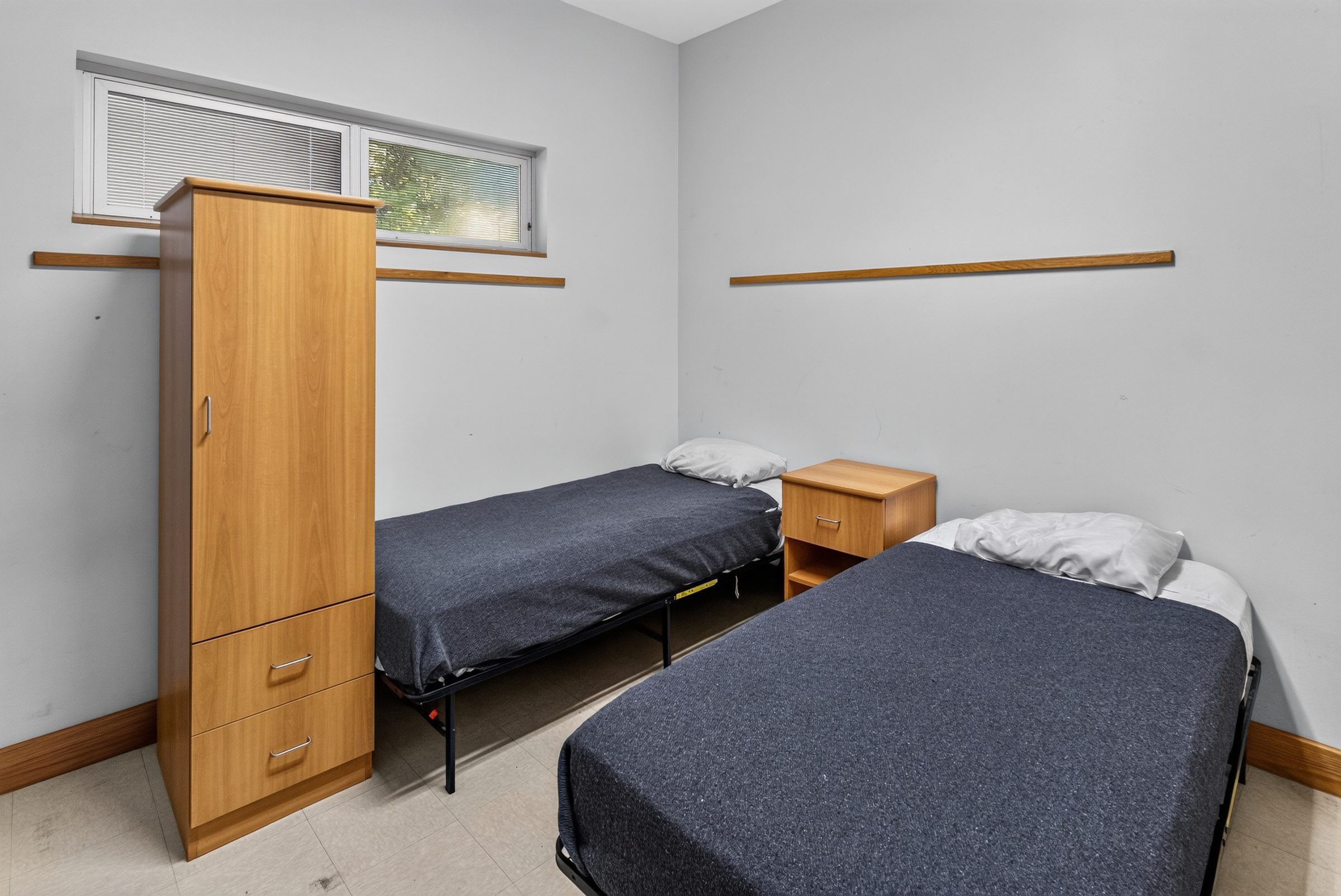 A two-bed resident room at Golden Grove Recovery in Louisville with a wardrobe and a window