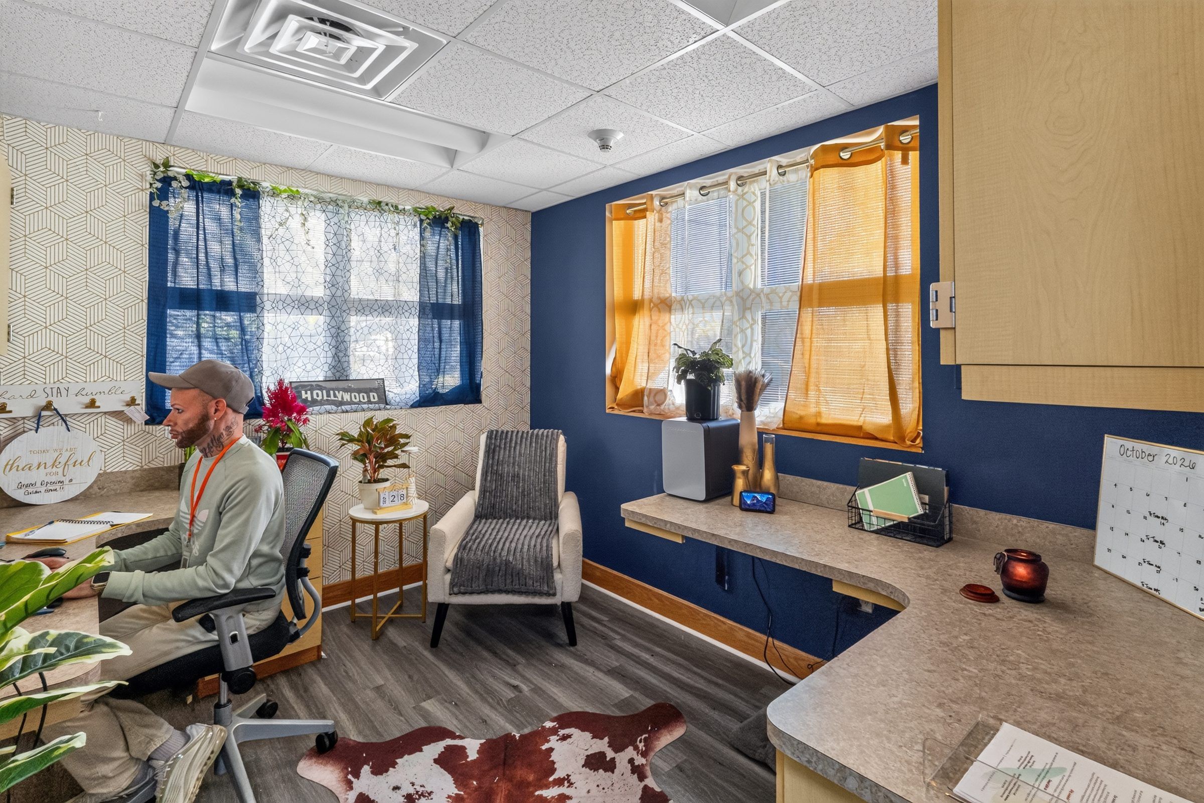 An office at Golden Grove Recovery in Louisville with a desk, an armchair and plants by the window
