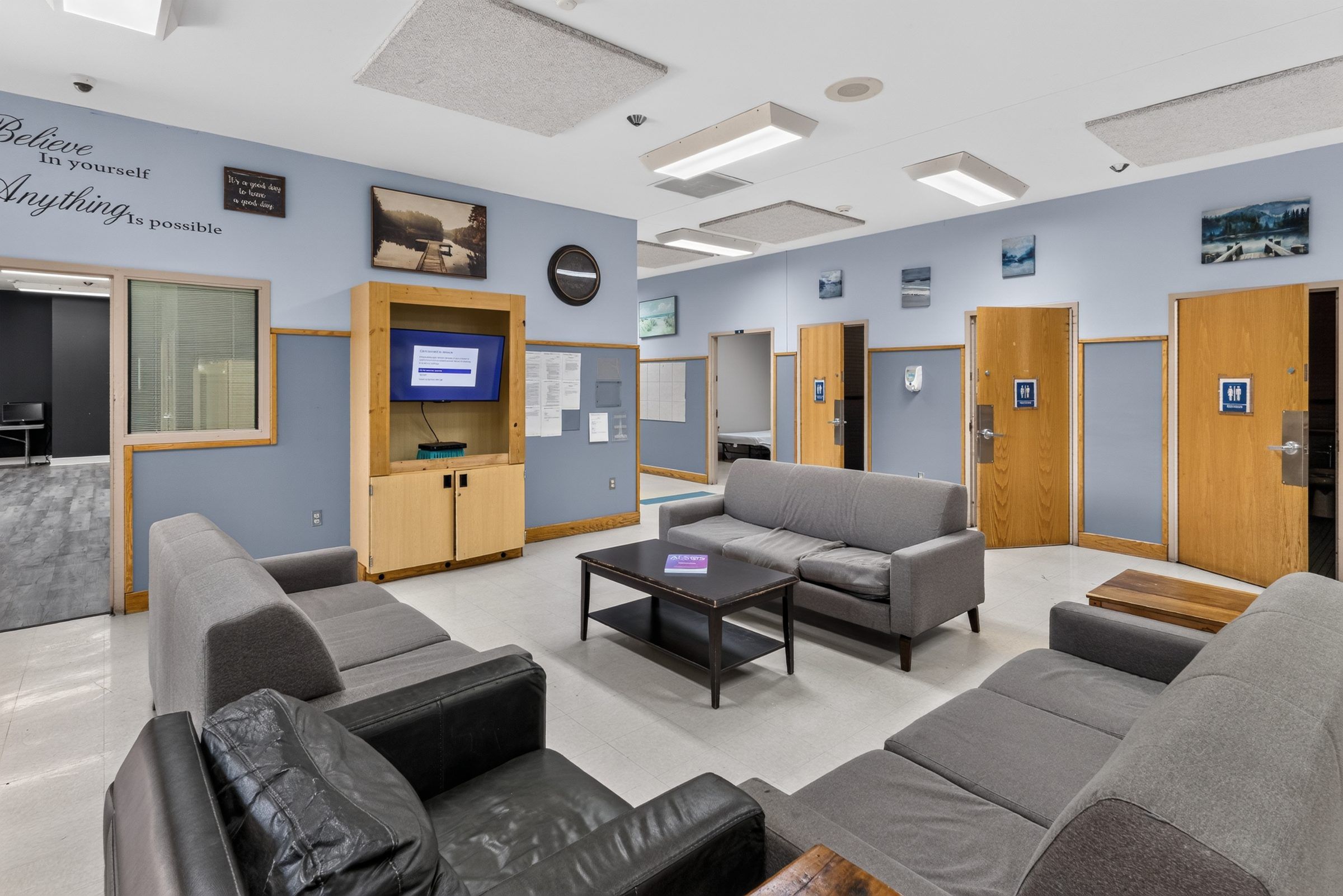 A second seating area at Golden Grove Recovery in Louisville with sofas, a coffee table and a TV cabinet